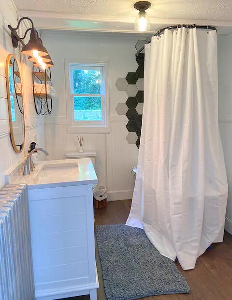 bathroom with wood-type flooring, radiator, a textured ceiling, and vanity