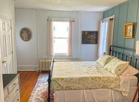 bedroom featuring radiator heating unit and dark wood-type flooring