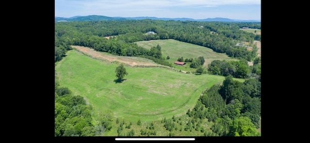 drone / aerial view featuring a wooded view and a mountain view