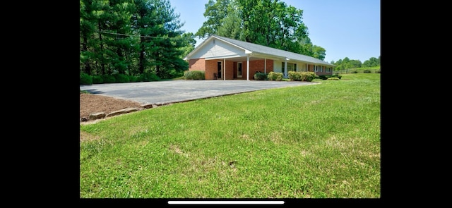 view of yard with an attached carport and driveway