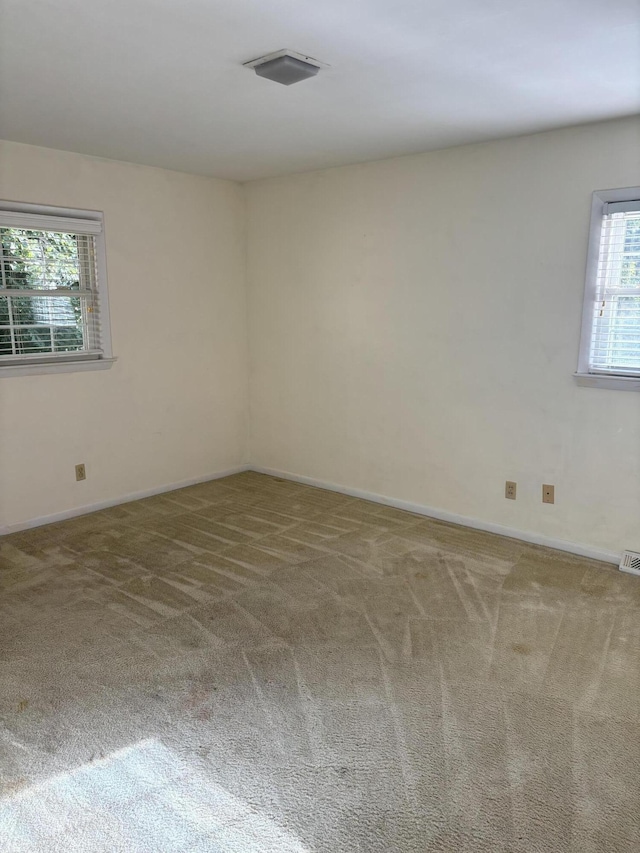 carpeted empty room with baseboards and visible vents