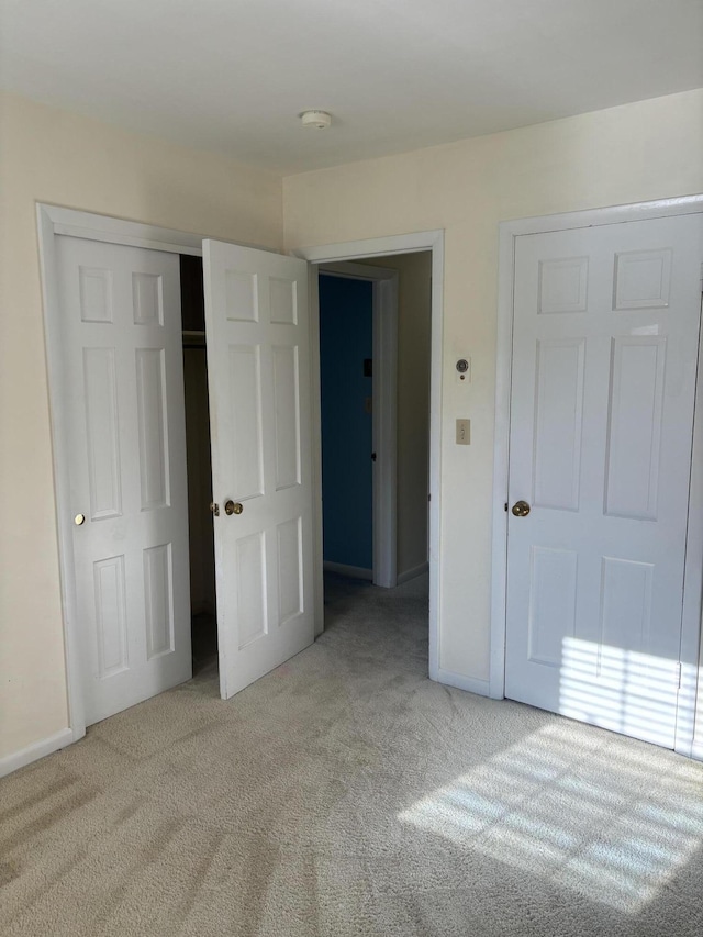 unfurnished bedroom with carpet floors, baseboards, and a closet