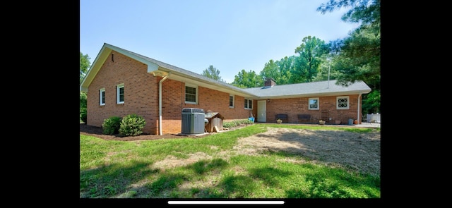 rear view of house with brick siding and central AC