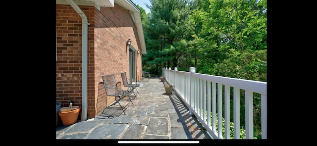 view of home's exterior with brick siding and a patio
