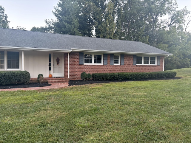 single story home featuring brick siding and a front lawn