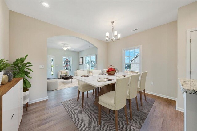 dining space with hardwood / wood-style flooring and a notable chandelier