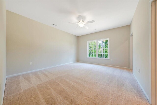 carpeted spare room with ceiling fan