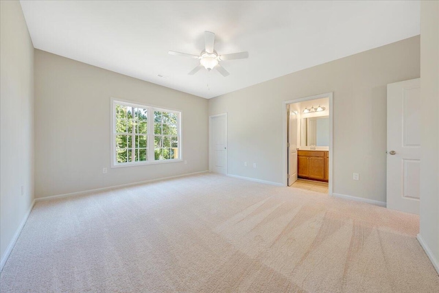 unfurnished bedroom featuring light carpet, connected bathroom, and ceiling fan