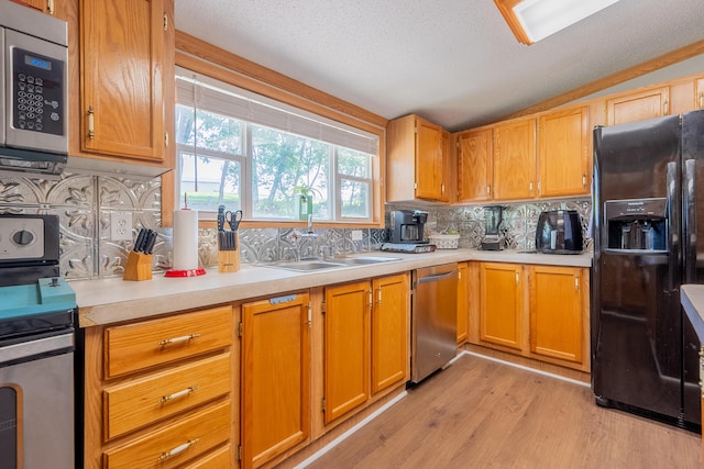 kitchen with vaulted ceiling, tasteful backsplash, sink, light hardwood / wood-style floors, and stainless steel appliances