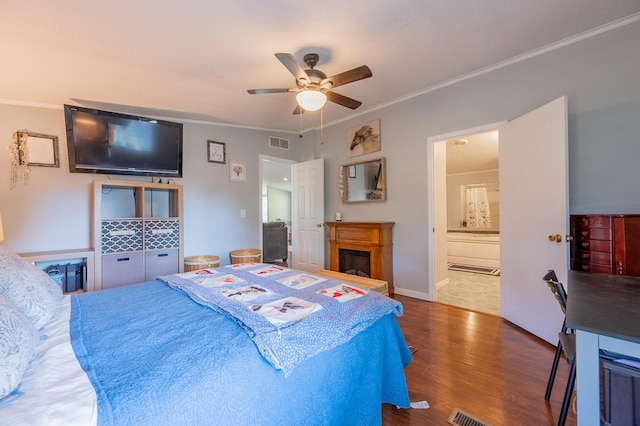 bedroom with ornamental molding, dark hardwood / wood-style floors, ensuite bathroom, and ceiling fan