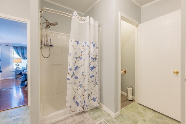 bathroom with ornamental molding and walk in shower