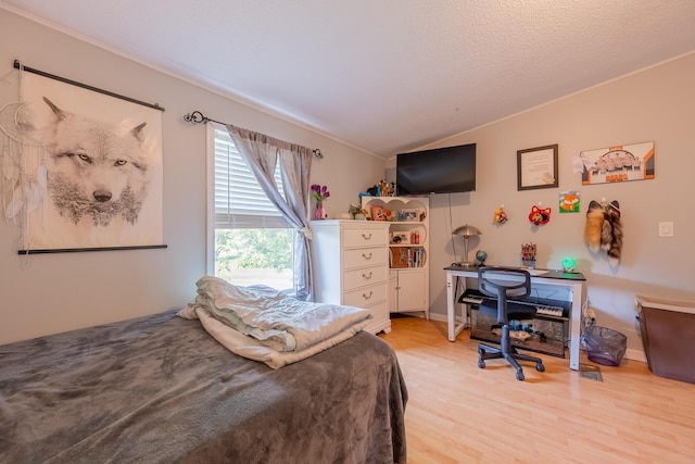 bedroom with vaulted ceiling and light hardwood / wood-style flooring