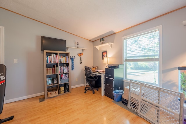 office space featuring ornamental molding, vaulted ceiling, and light wood-type flooring