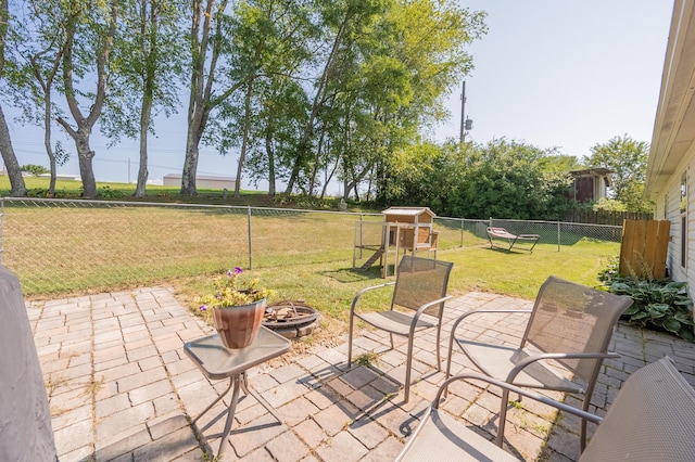 view of patio / terrace with a playground and a fire pit