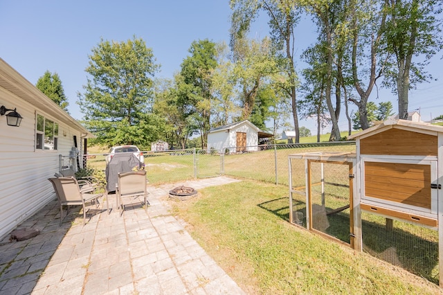 view of yard with an outbuilding, an outdoor fire pit, and a patio