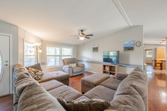 living room with ceiling fan, a textured ceiling, vaulted ceiling, and wood-type flooring