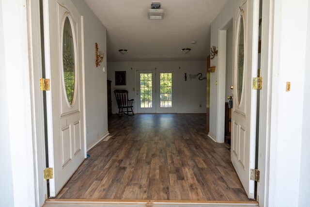 hallway featuring french doors, dark hardwood / wood-style flooring, and a textured ceiling