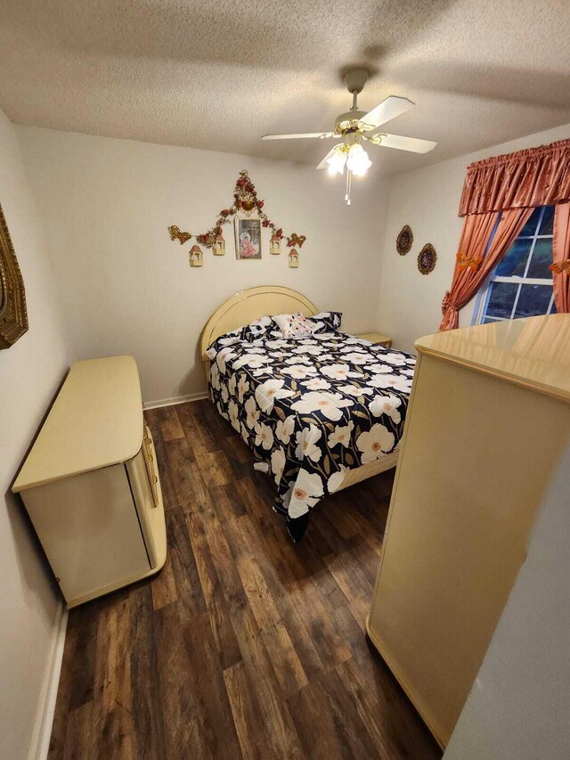 bedroom featuring dark wood-type flooring, ceiling fan, and a textured ceiling