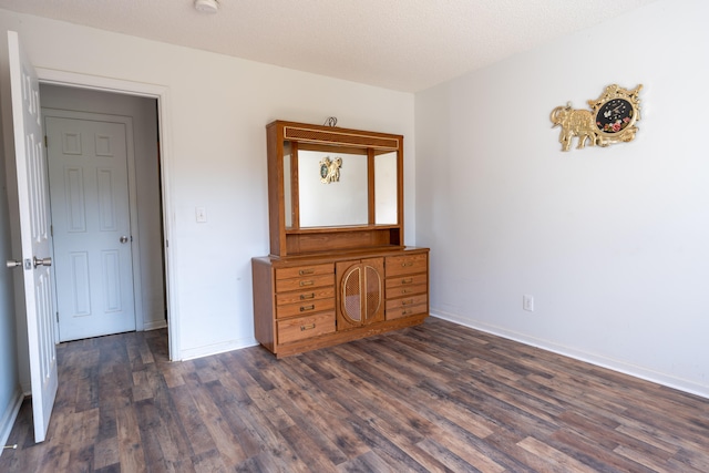 unfurnished bedroom featuring dark hardwood / wood-style flooring and a textured ceiling