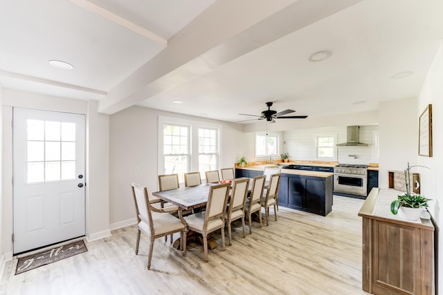 dining area with ceiling fan, sink, and light wood-type flooring