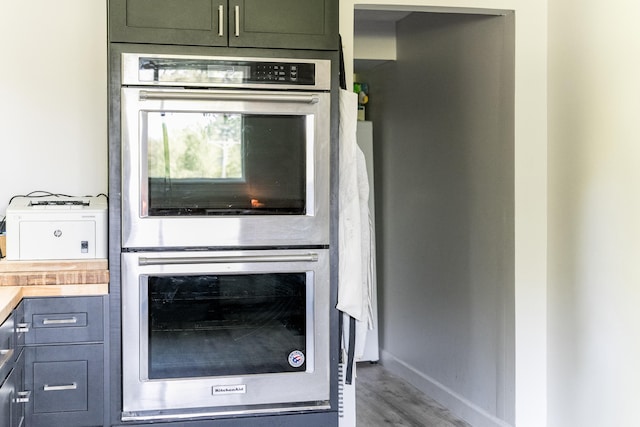 kitchen featuring double oven, hardwood / wood-style flooring, and butcher block counters