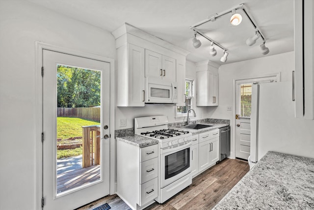 kitchen with white cabinets, a wealth of natural light, sink, and white appliances