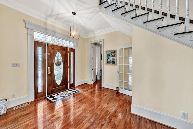 entryway featuring hardwood / wood-style floors, a notable chandelier, and ornamental molding