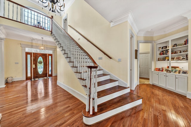 entrance foyer featuring an inviting chandelier, a healthy amount of sunlight, and light hardwood / wood-style flooring