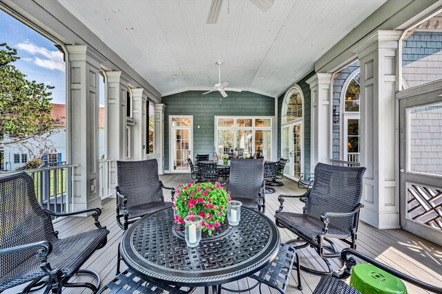 sunroom featuring lofted ceiling, ceiling fan, and decorative columns