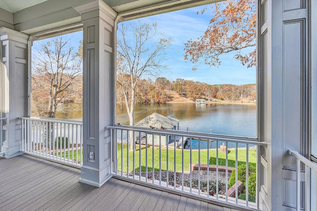 deck with a lawn and a water view