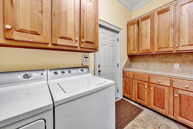 laundry area featuring ornamental molding, separate washer and dryer, and cabinets