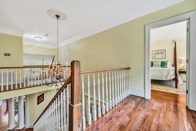 hall featuring a chandelier, hardwood / wood-style floors, and crown molding