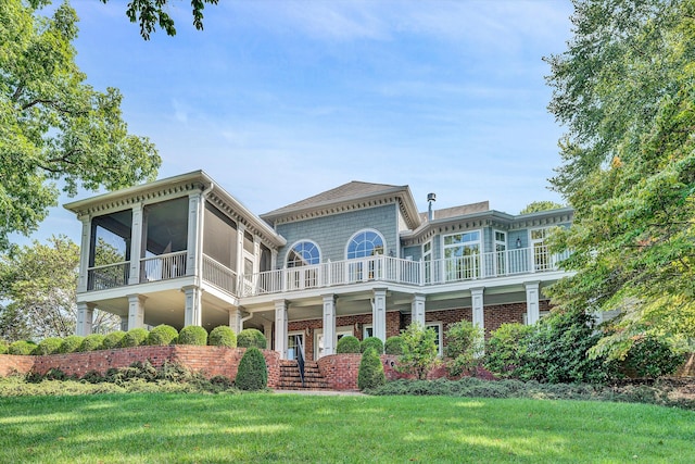 back of house with a balcony, a sunroom, and a yard