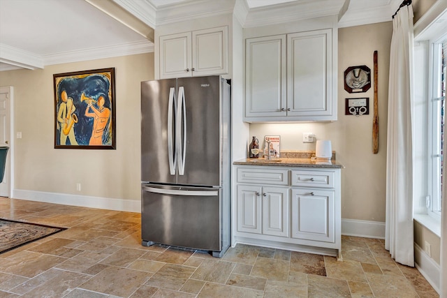 kitchen with white cabinets, a wealth of natural light, and stainless steel refrigerator