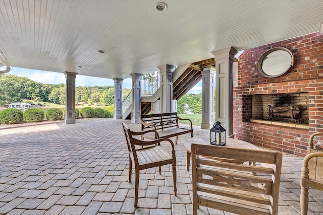 view of patio featuring an outdoor brick fireplace