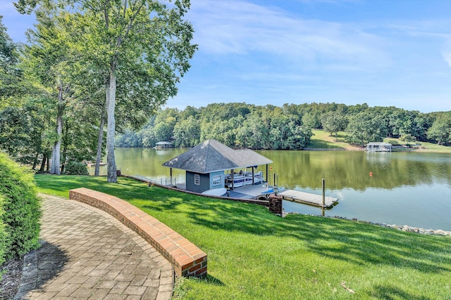 view of dock with a lawn and a water view