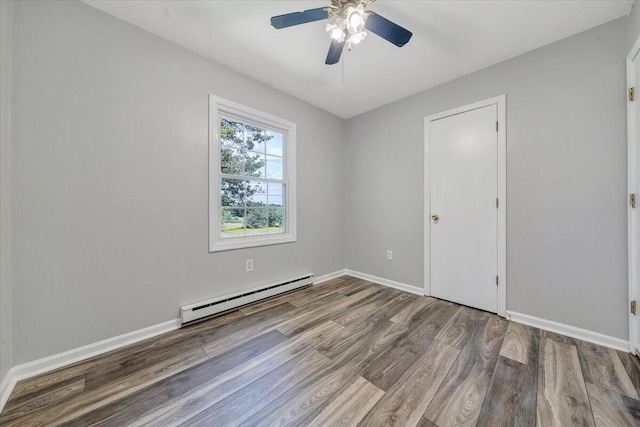 unfurnished room featuring a baseboard heating unit, ceiling fan, and hardwood / wood-style flooring