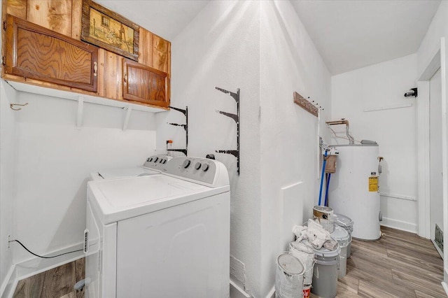 laundry room with separate washer and dryer, light hardwood / wood-style flooring, cabinets, and water heater