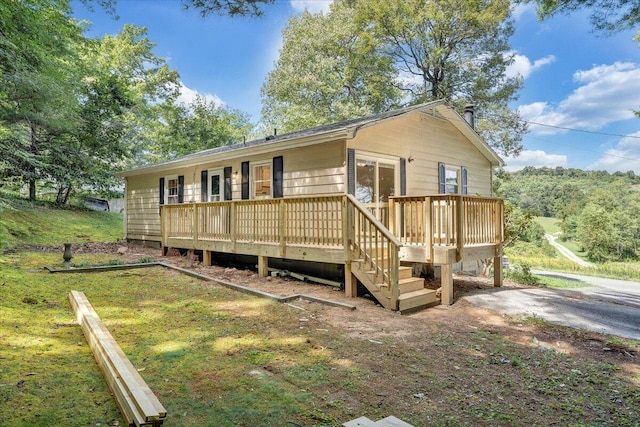 view of front of house featuring a wooden deck and a front yard