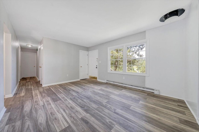 spare room with wood-type flooring and baseboard heating