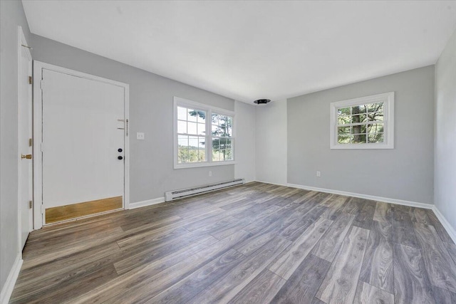 empty room with baseboard heating and wood-type flooring