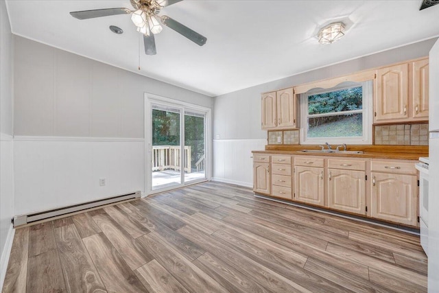 kitchen with light brown cabinetry, light hardwood / wood-style flooring, a baseboard heating unit, sink, and ceiling fan