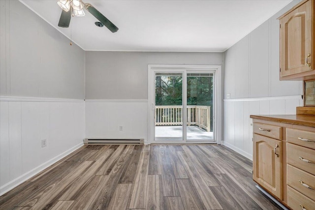 unfurnished dining area featuring light wood-type flooring, ceiling fan, and baseboard heating