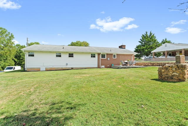 rear view of house featuring a lawn and a patio area