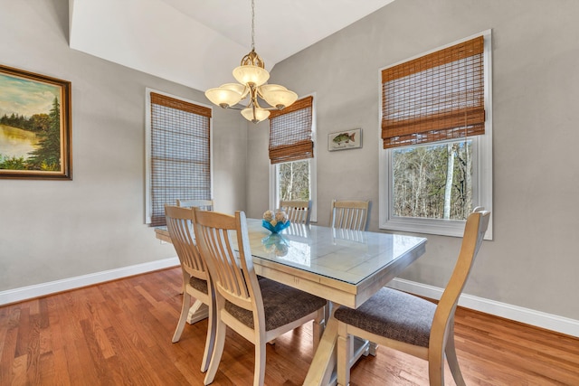 dining space featuring a wealth of natural light, an inviting chandelier, and hardwood / wood-style flooring