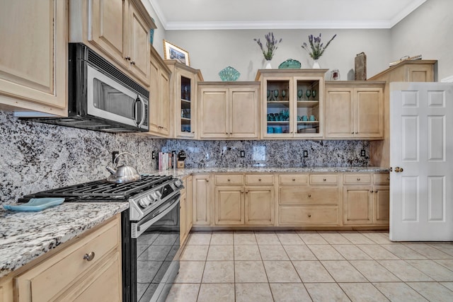 kitchen featuring light tile patterned floors, appliances with stainless steel finishes, light brown cabinets, and light stone countertops