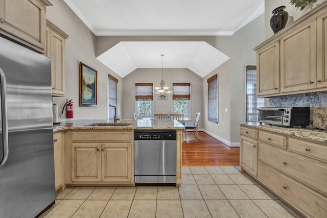 kitchen featuring light brown cabinetry, appliances with stainless steel finishes, light hardwood / wood-style floors, a notable chandelier, and sink