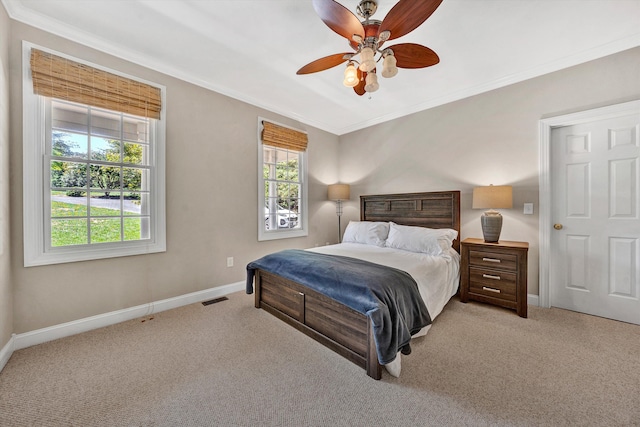 bedroom featuring light carpet, crown molding, and ceiling fan