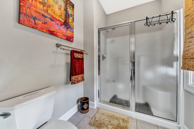 bathroom featuring toilet, an enclosed shower, and tile patterned floors