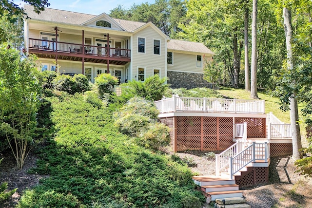 rear view of property featuring a wooden deck and a balcony